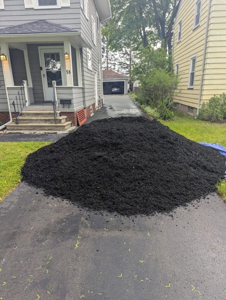 Close-up of black mulch pile staged in a driveway in Irondequoit NY