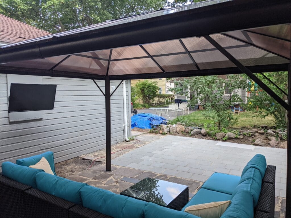 Newly installed patio covered by a gazebo with patio furniture, showcasing professional hardscaping services by EJ Lawn & Landscape in Irondequoit, NY