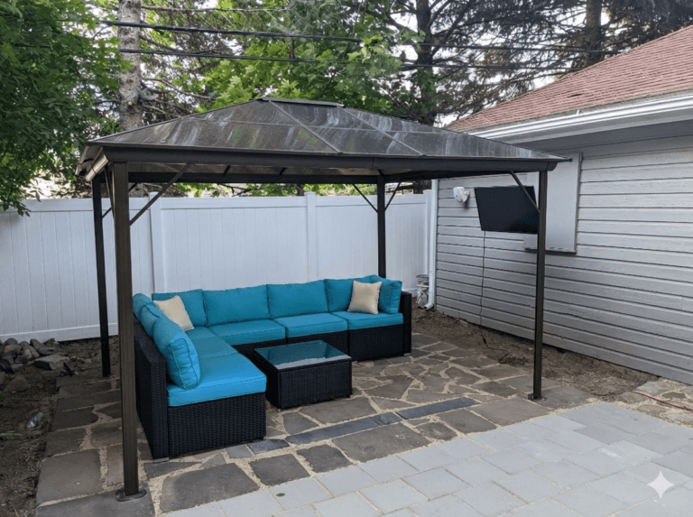 New stone patio with gazebo and outdoor furniture installed as part of custom hardscaping in Rochester NY