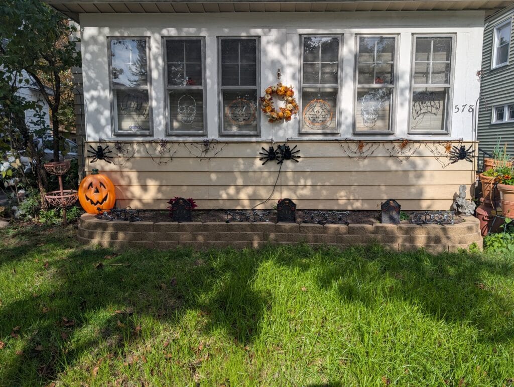 Finished stone retaining wall with fresh green grass in front yard Rochester NY