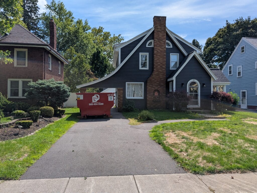 Dumpster in driveway during yard cleanup and junk removal in Irondequoit NY