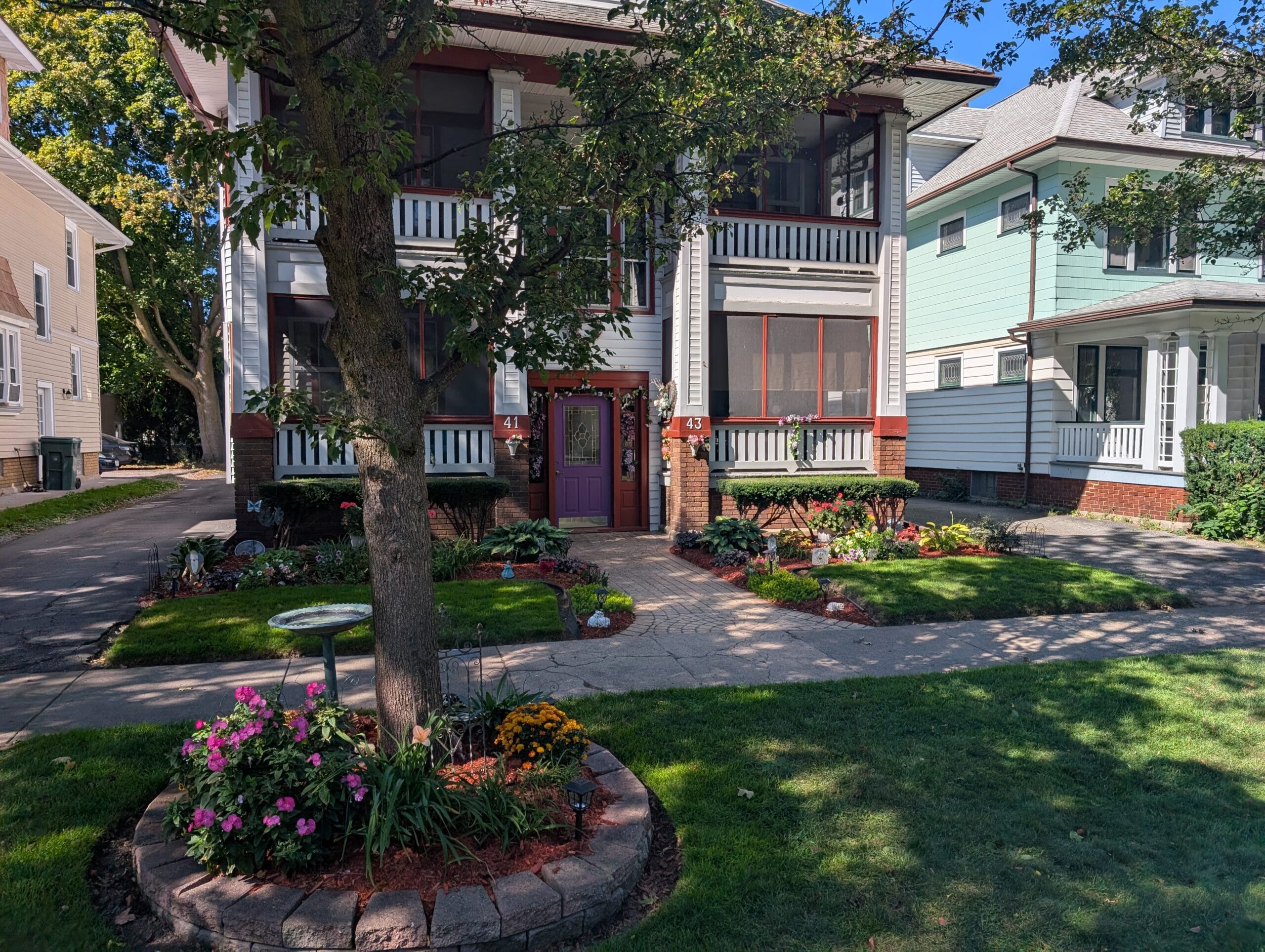 Front yard garden with trimmed bushes and seasonal planting in Rochester, NY