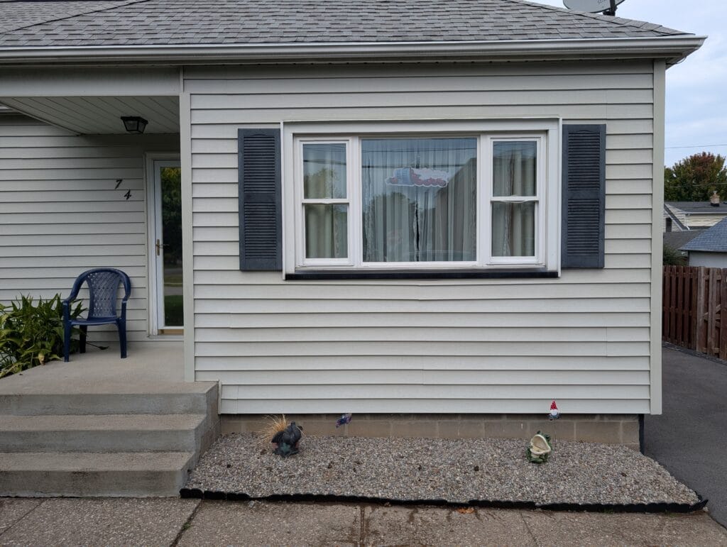 Landscape rock spilling onto sidewalk due to failing garden edging in Irondequoit NY
