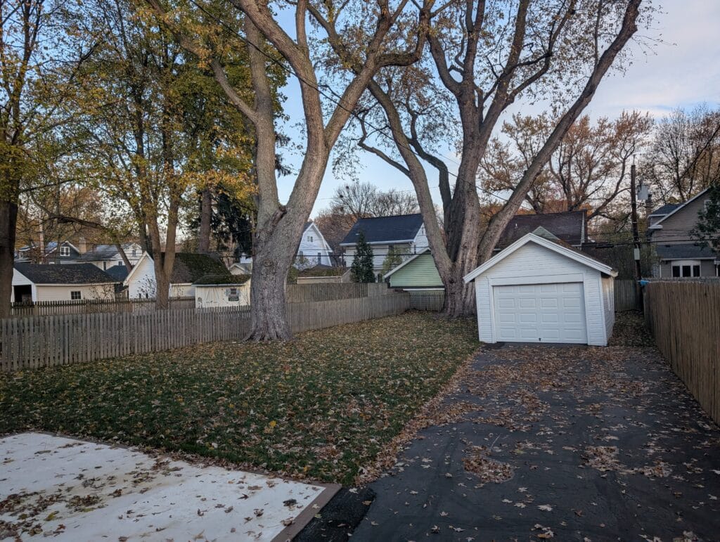 Backyard covered with leaves before leaf blowing service in Irondequoit NY