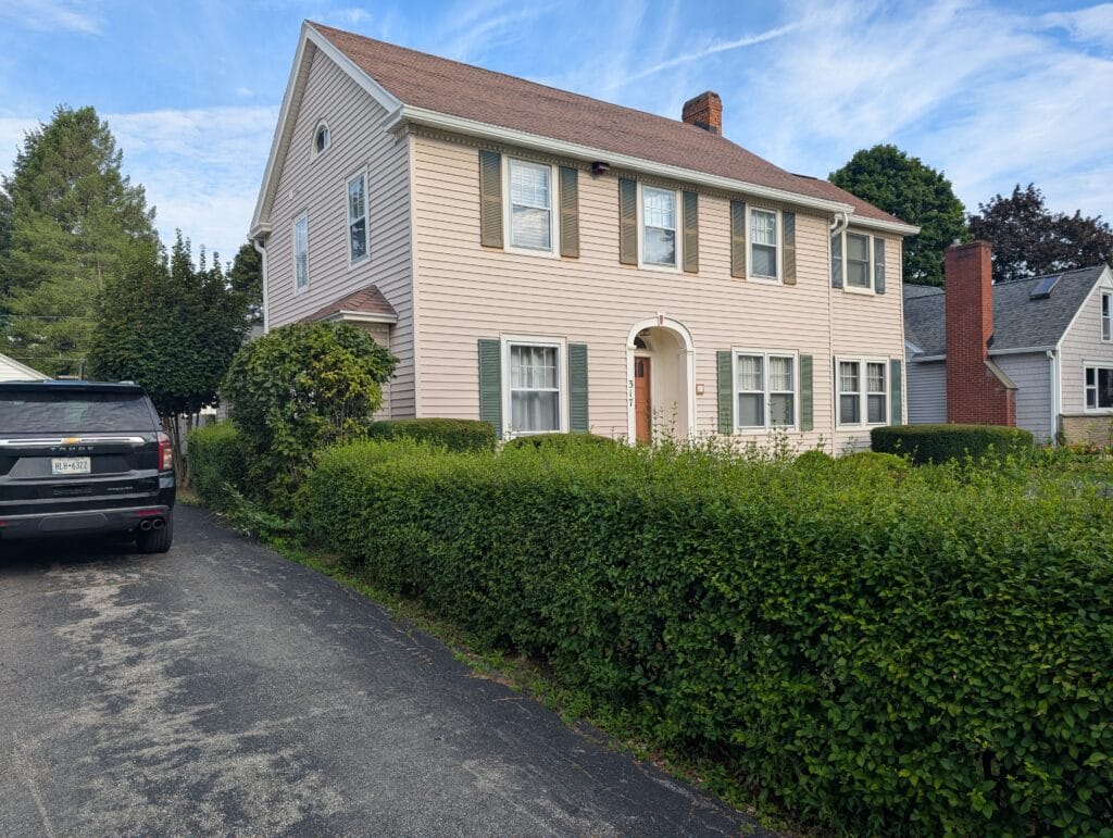 Overgrown shrubs before seasonal bush trimming in Brighton NY