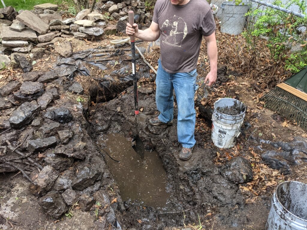 Excavating pond dirt and debris in Irondequoit, preparing the site for a new patio.
