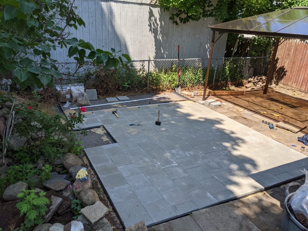 Paver patio nearly complete in Irondequoit with most stones installed.