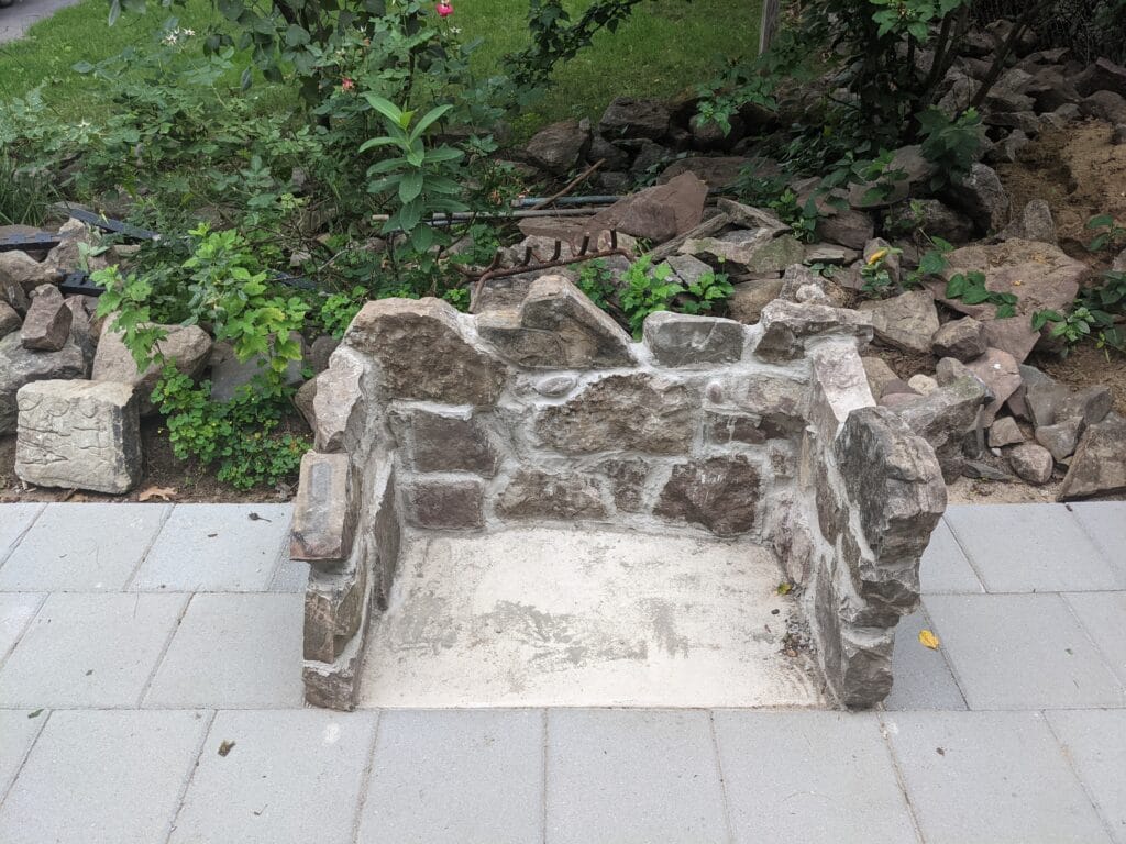 First layers of stone being stacked for outdoor fireplace in Irondequoit