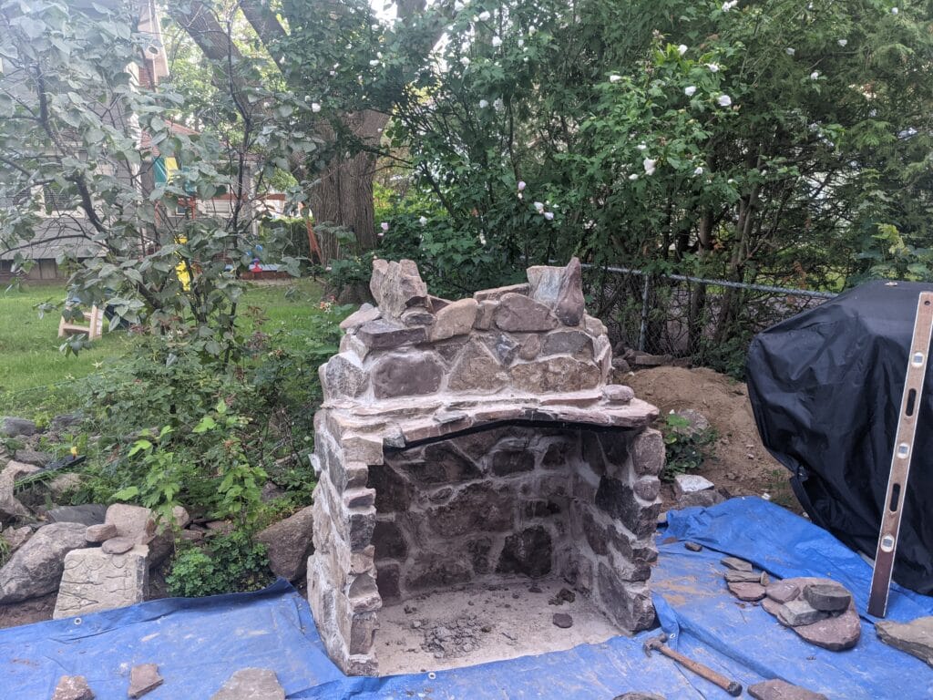 Stone fireplace halfway constructed on patio in Irondequoit NY