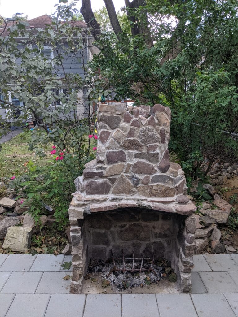 Completed stone fireplace built from reclaimed pond rock in Irondequoit