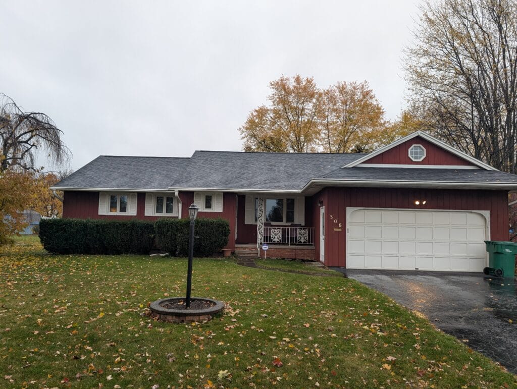 Overgrown front yard bushes at a home in Greece, NY before trimming