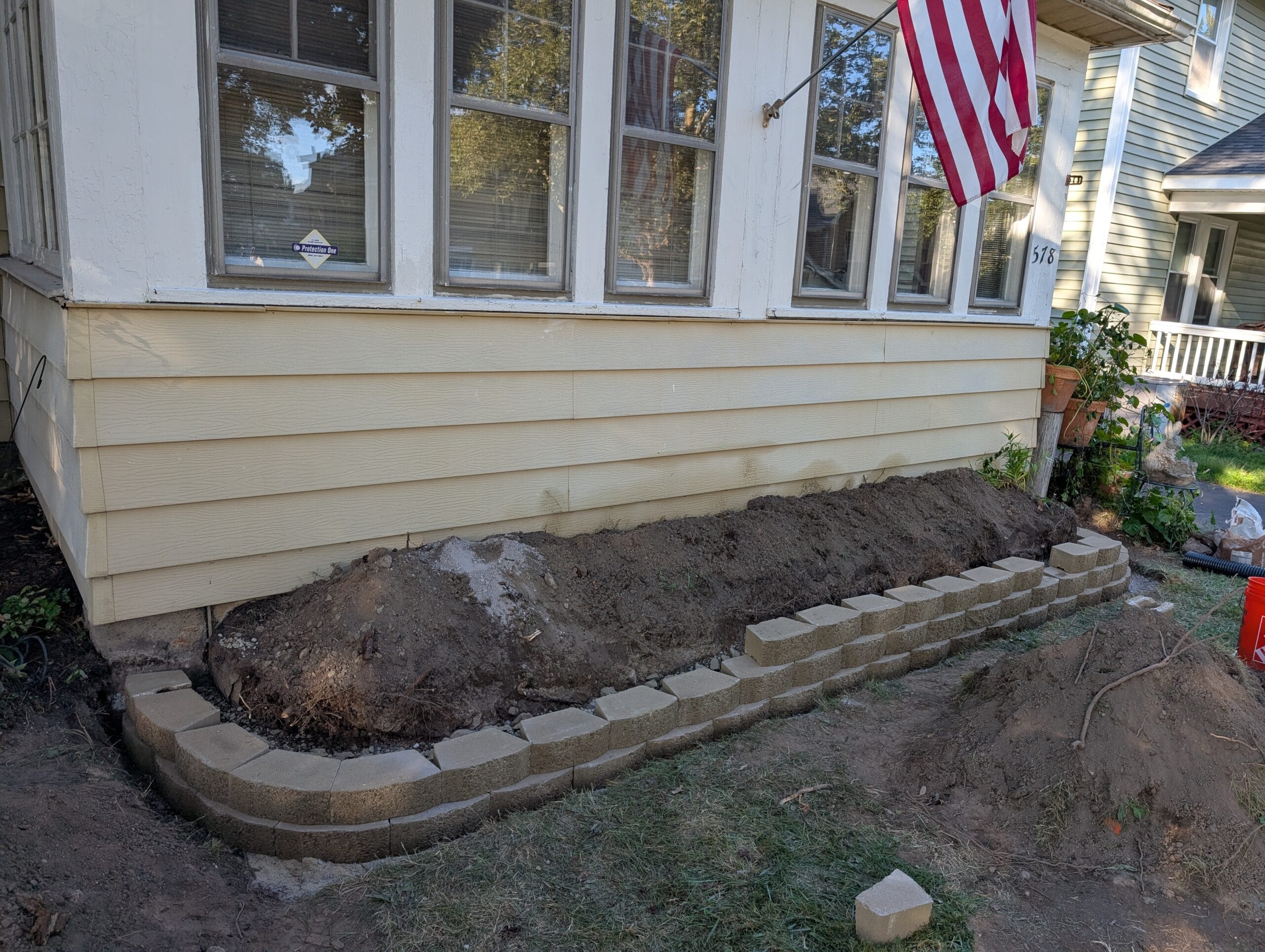 Stone retaining wall halfway installed in front yard in Rochester NY