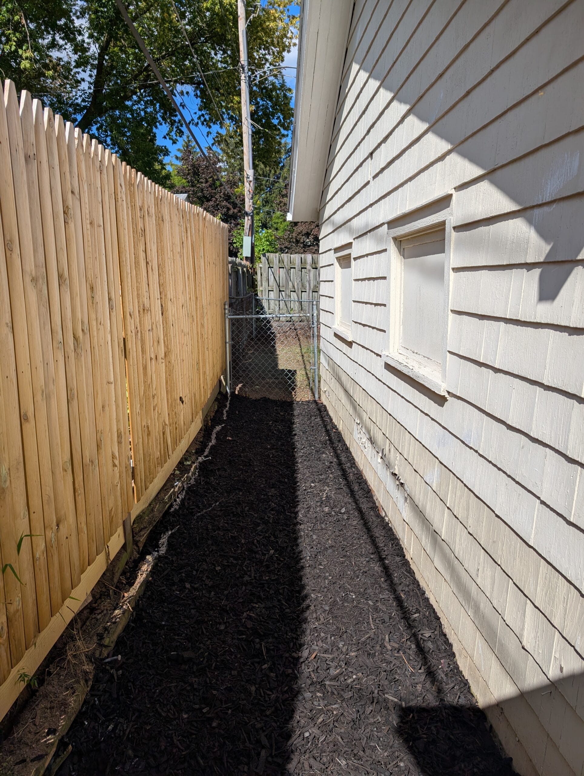 Side of garage with freshly installed mulch in Rochester, NY