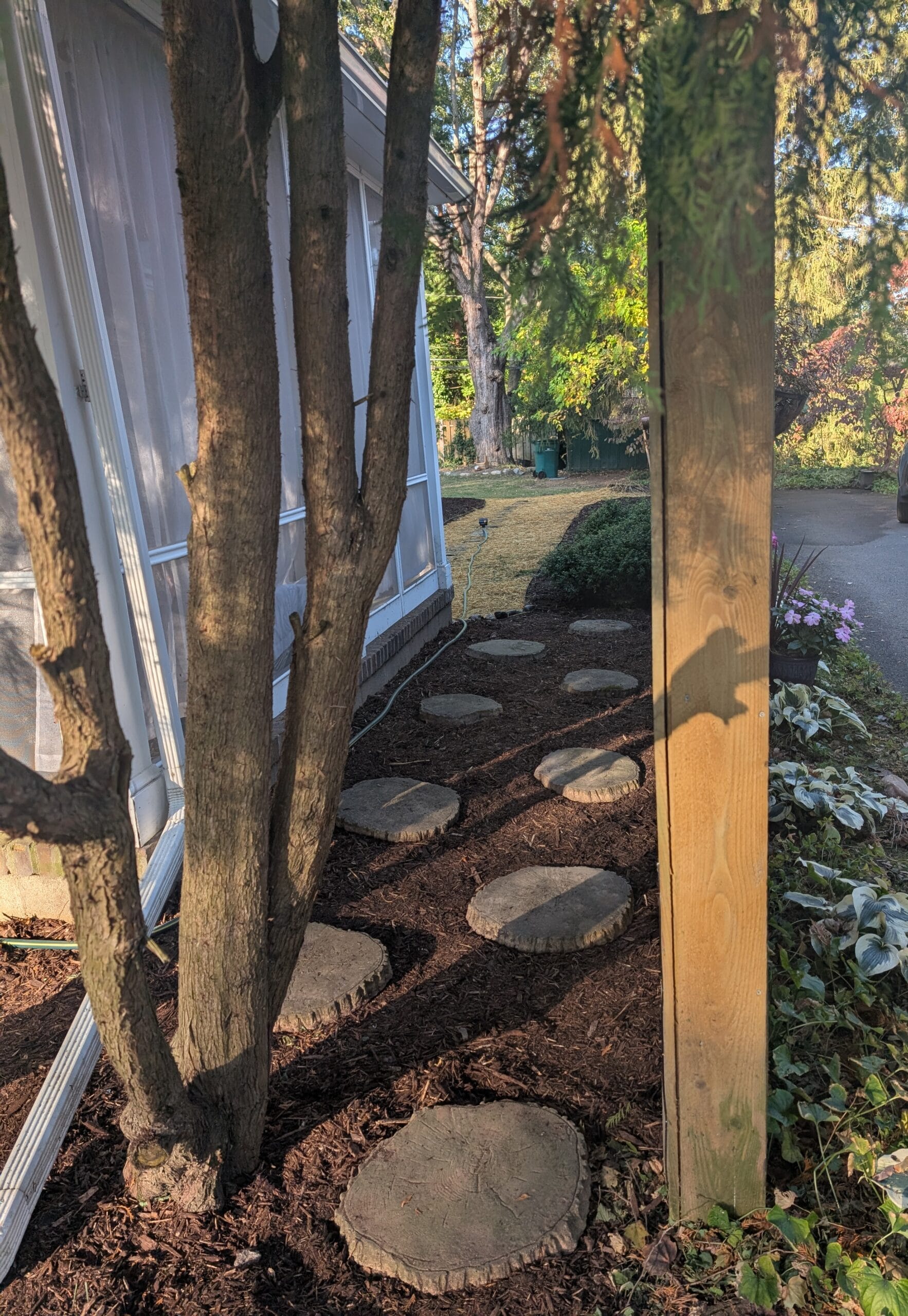 Mulched garden area with step stones and healthy plants in Rochester, NY