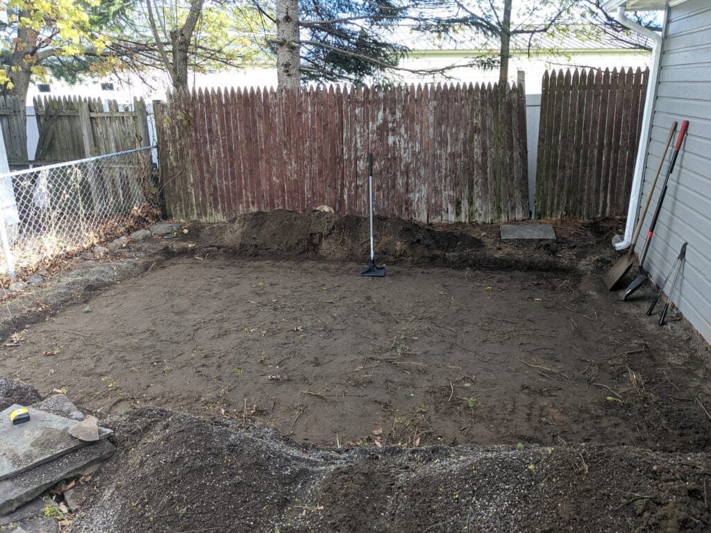 Backyard area leveled and tamped in Irondequoit, ready for natural stone patio installation.