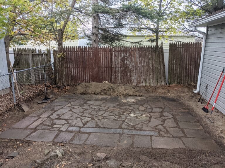 Alternate view of the completed natural stone patio in Irondequoit, showing the flowing layout and craftsmanship.