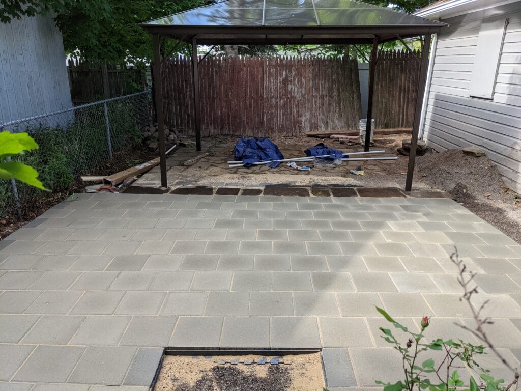 Completed paver patio in Irondequoit, installed over a former pond area, with level stones and finished edges.