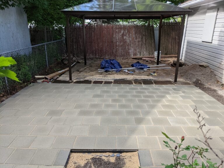Completed paver patio in Irondequoit, installed over a former pond area, with level stones and finished edges.