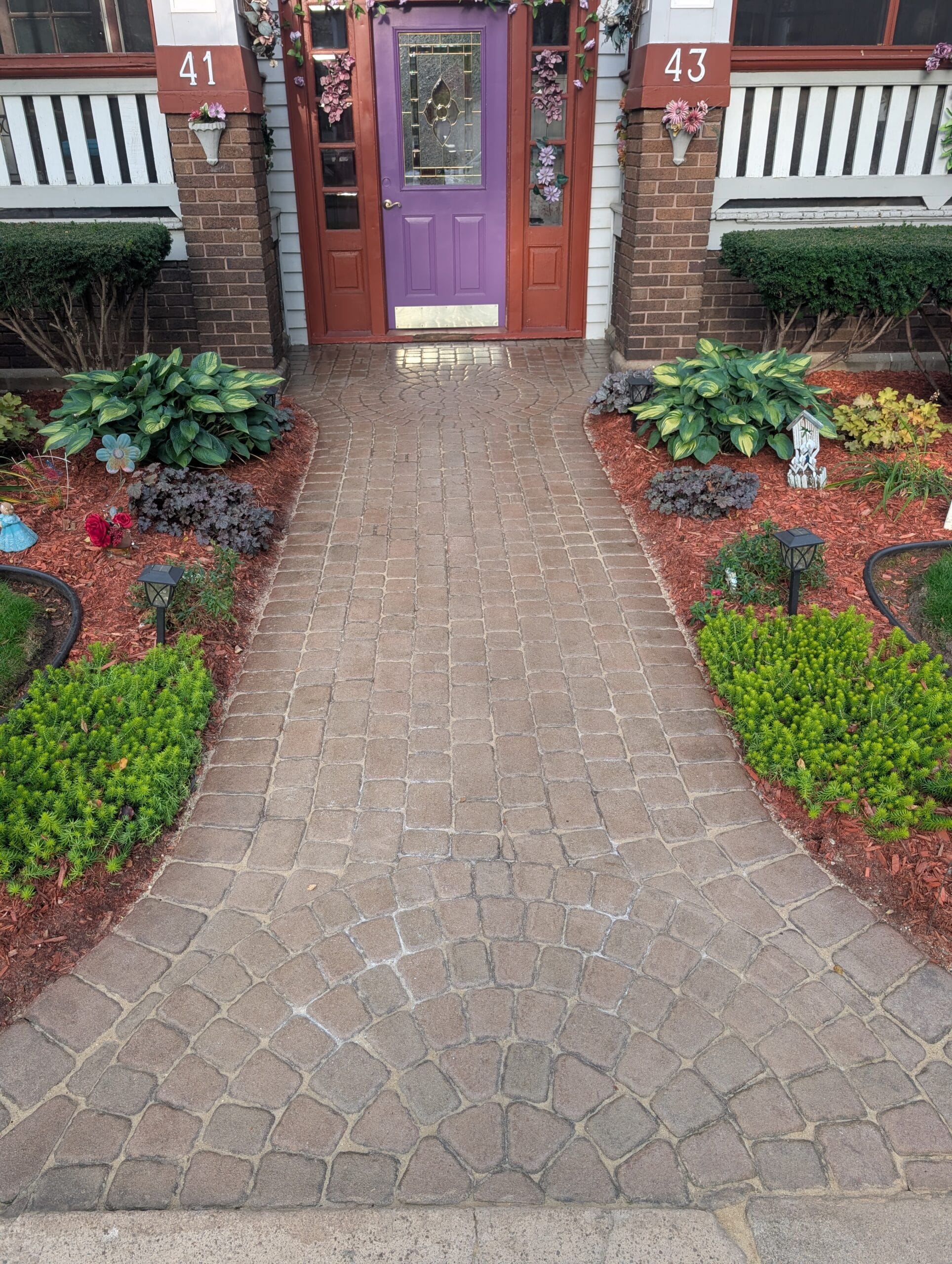 Paver walkway leading to a home’s front door in Irondequoit, showing clean, level stones and well-defined edges.